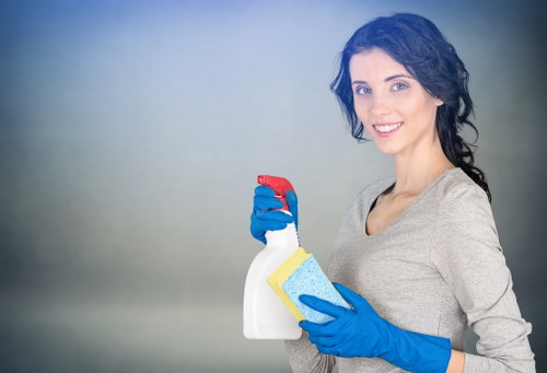 Trained cleaner using protective gloves and footwear during carpet cleaning